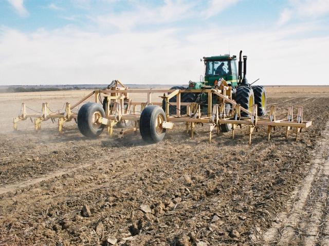 The photo shows a deep ripper working with the tines lifted behind the wheel tracks to set up permanent tramlines for a controlled traffic system