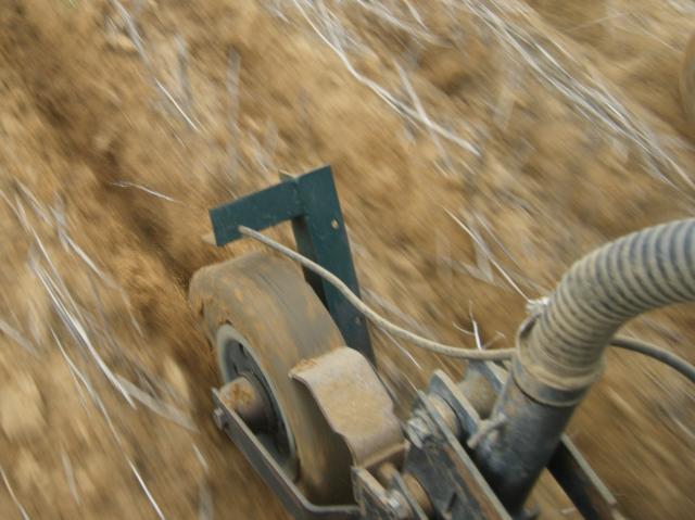 Firming of a furrow in water repellent sandy topsoil using a rectangular shaped profile press wheel