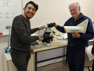 Two men with a microscope and spore trap.