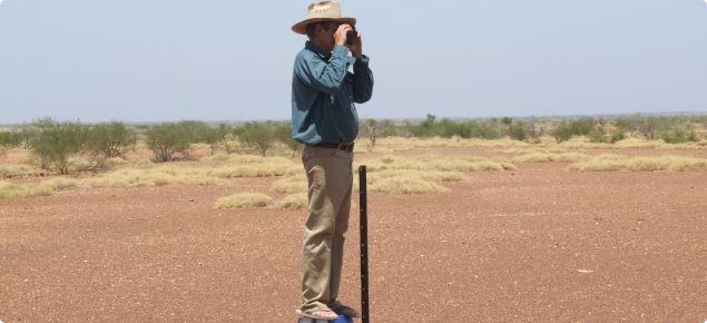 Photograph of rangeland station manager taking a photo on a monitoring site