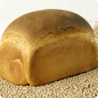 A loaf of bread made with lupin flour, sitting on a bed of Australian sweet lupin seed.