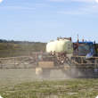 Boom spray applying chemical over pasture paddock