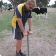Photograph of a person leaning on a manual pogo stick soil sampler